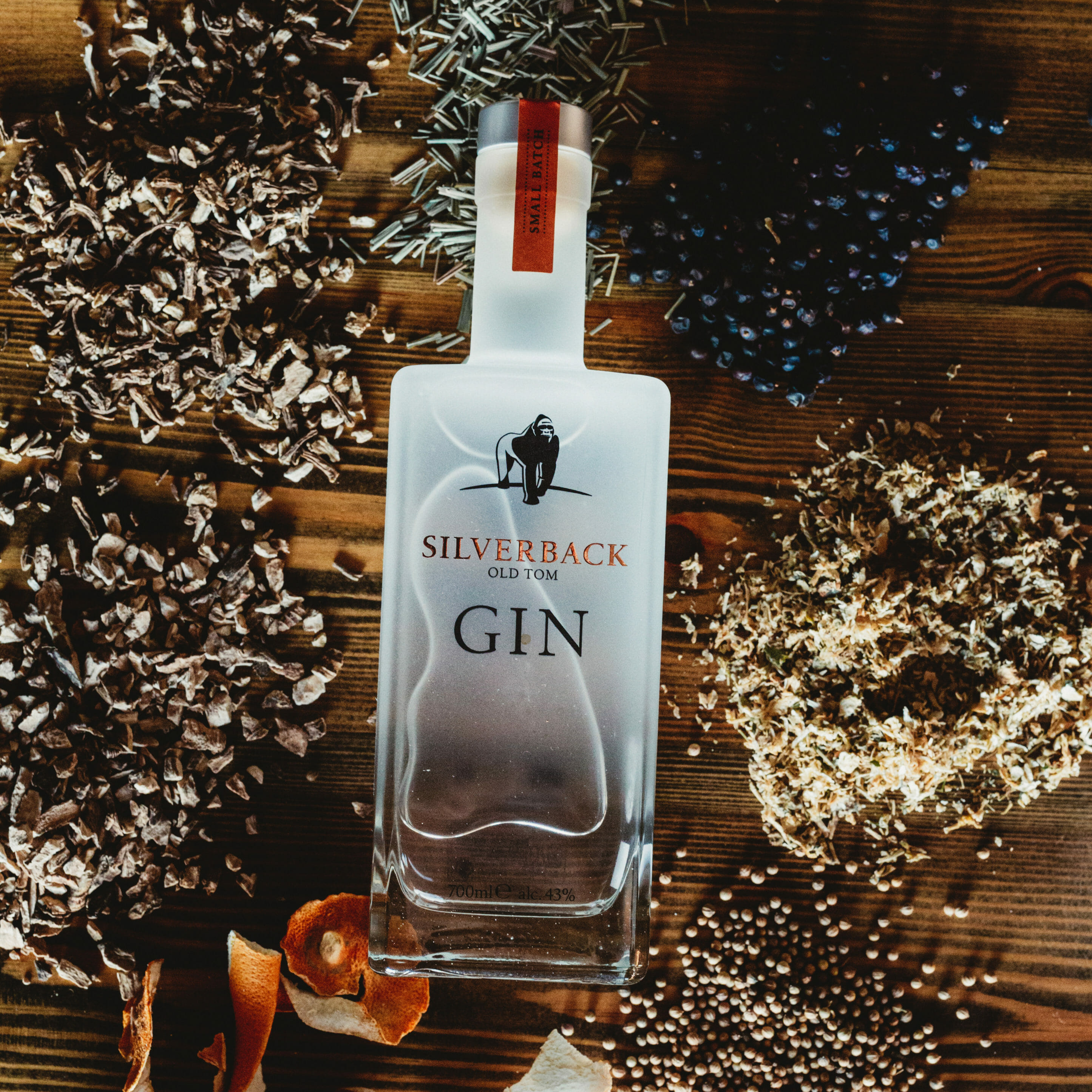 Silverback Old Tom Gin surrounded by botanicals such as coriander, juniper berries, orange peel, and angelica root used to craft the spirit - Gorilla Spirits Co.